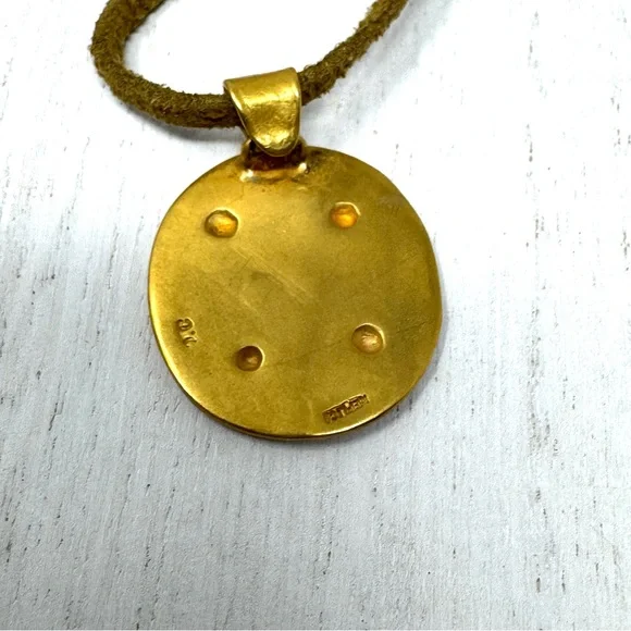 Mayan design gold tone pendant purchased in Costa Rica, on golden suede cord